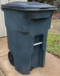 A garbage can on a sidewalk

Description automatically generated
